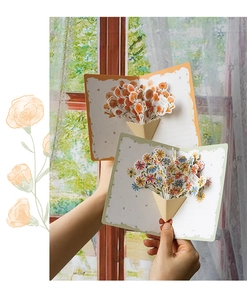 Detailed view of open 3D flower pop-up cards featuring orange and colorful floral bouquets