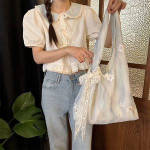 Detail of floral embroidery and delicate lace trim on the large canvas tote bag