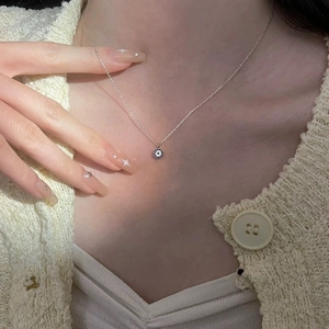 Detail of 14K gold plated sterling silver evil eye pendant necklace on collarbone
