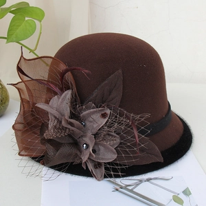 Detailed shot of a vintage brown felt bowler hat with feathers, mesh floral and black beads