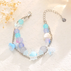 Detalle de pulsera de cuentas coloridas con dijes de corazón, mariposa y cadena