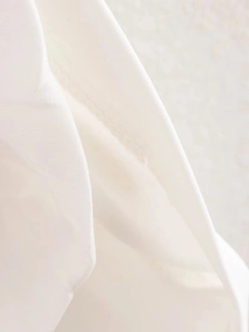 Gros plan détaillé sur la texture du tissu blanc tricoté et les coutures de la robe