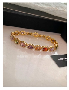 Macro shot of gold bracelet featuring colorful oval zircons and micro-pave detailing