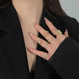 Close-up of model wearing six gold-tone resin rings with pleated and rhinestone details