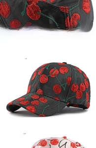 Detailed close-up of cherry embroidery and adjustable metal buckle on baseball cap