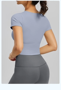 Top corto da yoga blu-grigio aderente e leggings visti da un'angolazione laterale posteriore