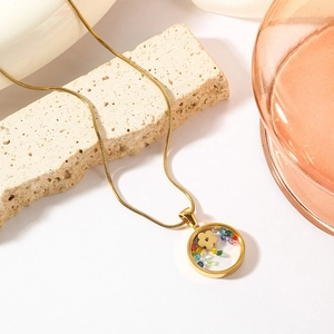 Gold plated evil eye geometric flower pendant necklace on stone display