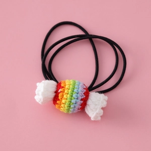 Detail of colorful knitted candy-shaped hair tie on soft pink background for girls