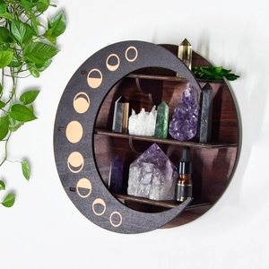 Detail of bohemian round wooden moon phase shelf displaying crystals and essential oils