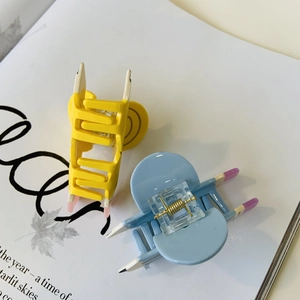 Detail of candy-colored acetate pencil hair clips on a magazine with leaf motifs