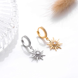 Detailed view of silver and gold sunburst leverback earrings with pavé cubic zirconia
