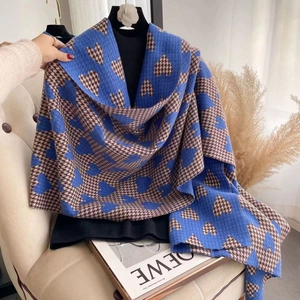 Close-up of blue and brown houndstooth scarf with heart patterns on a beige sofa