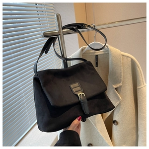 Dettaglio della borsa a tracolla in pelle scamosciata nera con fibbia vintage e metallo oro