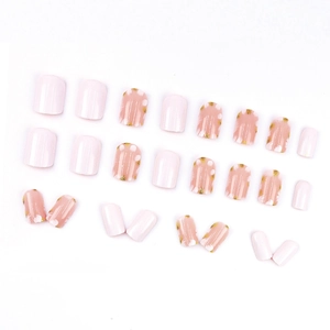 Short pink press-on nails set with gold foil flower accents and white petal designs