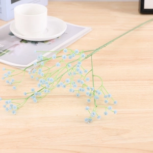 Detailed view of light blue gypsophila silk flowers on a minimalist wooden table