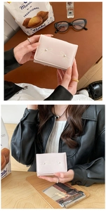 Detailed view of pink bow wallet with pearl accents shown in a lifestyle setting