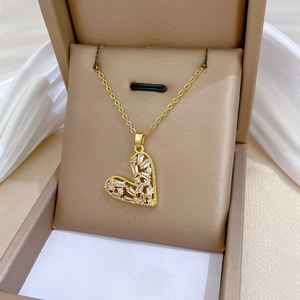 Macro shot of gold hollow heart pendant necklace with white rectangular zircons in a box