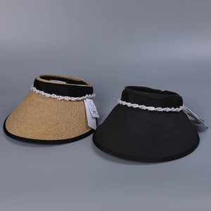 Detail of wide-brim sun visors with pearl chains in natural and black woven straw fiber