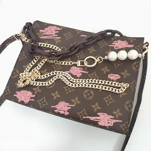 Brown monogram toiletry bag with gold metal chain and pearl decorative shoulder strap