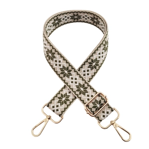 Close-up of ethnic geometric pattern strap with adjustable light gold metal hooks