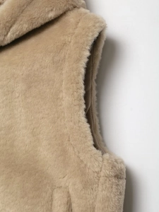 Detail of soft beige faux fur texture and stitching on the fashionable women's fleece vest