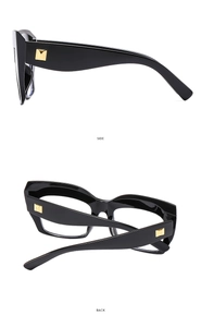 Detail view of black chunky cat-eye glasses frames with gold square stud accents