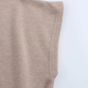 Detailed close-up of knitted fabric texture and neat side stitching on a brown midi skirt