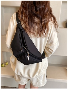 Rear view of a model wearing the black crossbody chest bag with wide shoulder strap