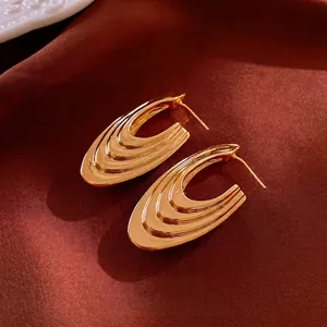 Chic gold-plated triple-layered teardrop U-shape hoop earrings on terracotta silk
