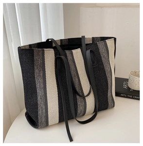 Close-up of black and grey vertical stripe knit texture and durable tote bag straps