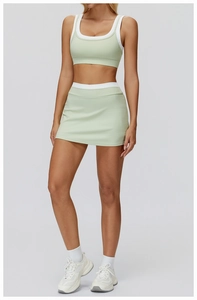 Detail view of light green and white athletic yoga set with sports bra and mini skirt