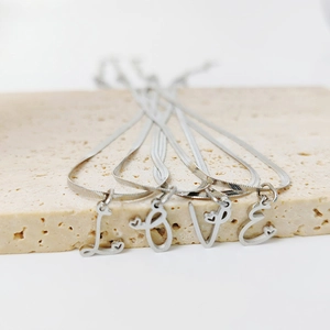 Detail of silver snake chain necklaces with L-O-V-E letter pendants and heart accents