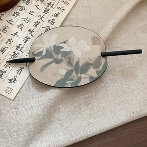 Nahaufnahme einer Haarspange aus Leder mit Blumenmuster und kalligraphischem Dekor