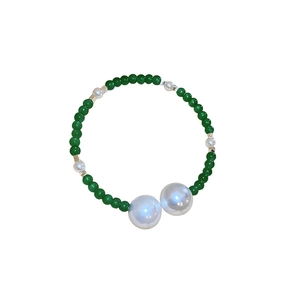 Vintage beaded bracelet with dark green glass beads and white pearls on white background