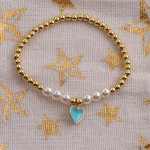 Detailed view of elastic heart bracelet with gold beads, pearls and sky blue charm