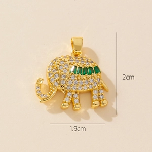 Gold elephant pendant necklace with white and green cubic zirconia stones on beige background