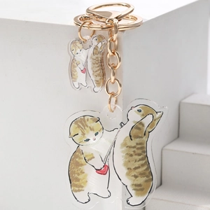 Close-up of acrylic keychains featuring cute cartoon cats on a white podium