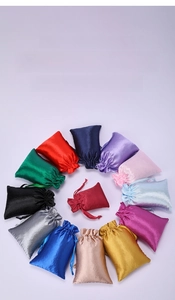 Macro view of colorful satin drawstring jewelry pouches with silk ribbon closure