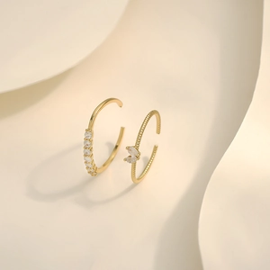 Detail of adjustable gold rings with sparkling zircon crystals and twisted metal texture