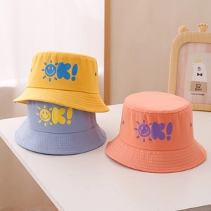 Dettaglio di cappelli da sole in cotone per bambini in giallo, blu e rosa con stampe