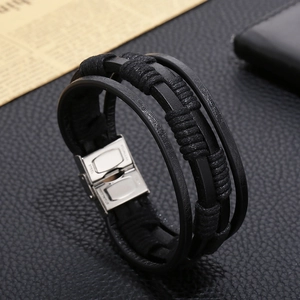 Detail of multi-layer black braided leather bracelet with polished stainless steel clasp