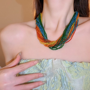 Dettaglio macro di una collana bohémien multistrato con perline colorate su modella
