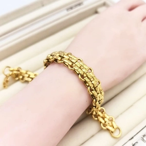 Detailed view of heavy gold-tone chain bracelet with intricate textured link patterns
