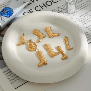 Detailed close-up of gold-plated boot and cowboy hat pendants with fine engravings