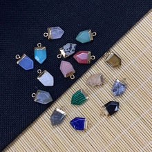 Variety of hexagonal natural stone crystal pendants with metal loops on bamboo mat