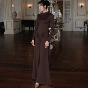 Detailed view of dark brown maxi dress with cinched waist pleats and long sleeves
