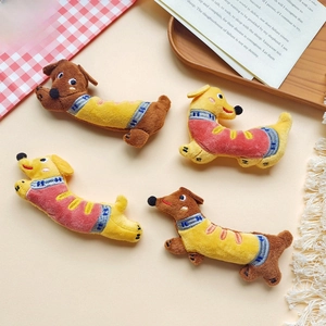 Detailed view of plush dachshund dolls featuring knitted blue scarves with H embroidery