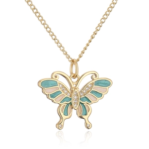 Macro detail of butterfly pendant with green enamel and zircons on 18K gold plated chain