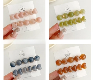 Detail showing heart and round resin hair clips in assorted marble jelly colors