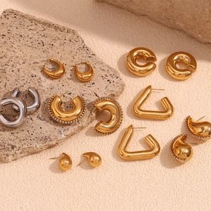 Détail de boucles d'oreilles géométriques dorées 18K et argentées sur pierre naturelle